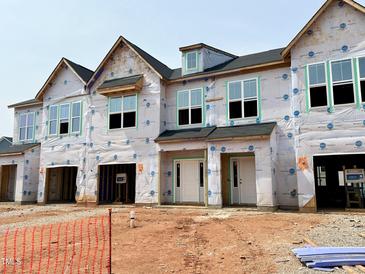 Exterior view of townhomes under construction, with visible framing, windows, and doors at 83 Ripple Way # 215, Clayton, NC 27520