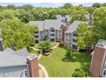Lovely aerial view of condominiums and walkways with mature trees, and lush green grass at 1061 Wirewood Dr # 303, Raleigh, NC 27605