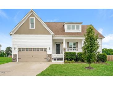 Charming two-story home with a two-car garage, inviting front porch, and manicured lawn showcasing curb appeal at 123 Pleasant View Ln, Benson, NC 27504