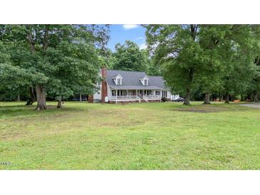 Charming home with a brick chimney and welcoming front porch surrounded by mature trees at 1401 Berea Rd, Rougemont, NC 27572