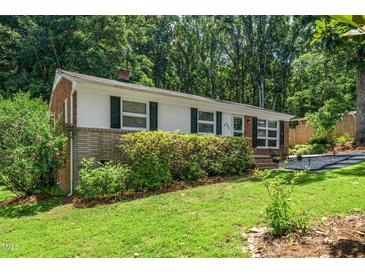 Charming single-story home with a manicured lawn, brick accents, and classic black shutters at 202 Crest Rd, Cary, NC 27513