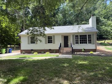 Charming single-story home with a landscaped yard and inviting brick stairs leading to the front door at 216 Burkwood Ln, Raleigh, NC 27609