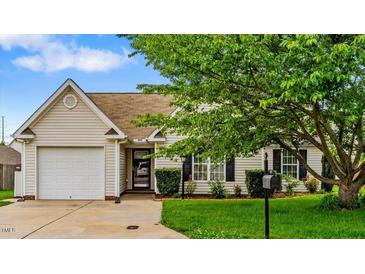 Charming single-story home featuring an attached two-car garage and manicured front lawn at 305 Slate Dr, Gibsonville, NC 27249