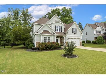 Charming two-story home featuring a well-manicured lawn, lush landscaping, and attached two-car garage at 347 Country Mill Way, Fuquay Varina, NC 27526