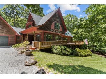Stunning wood home with a large deck, charming design, and inviting curb appeal surrounded by lush trees at 4110 Stoneycreek Rd, Chapel Hill, NC 27514