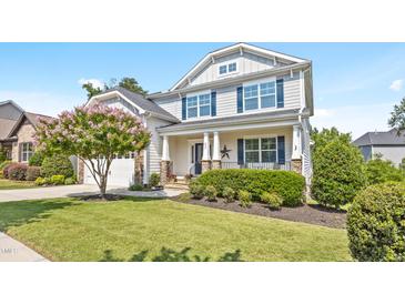 Charming two-story home features a well-manicured lawn and a blooming tree, creating a welcoming curb appeal at 633 Copper Beech Ln, Wake Forest, NC 27587