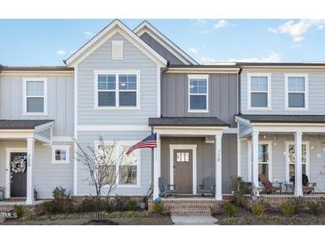 Charming townhome boasts a covered front porch, American flag, and beautiful neutral-tone exterior at 728 Silo Park Dr, Wake Forest, NC 27587
