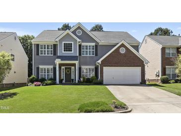 Traditional two-story home boasts manicured lawn, gray siding, and a two-car garage at 107 Trackimire Ln, Apex, NC 27539