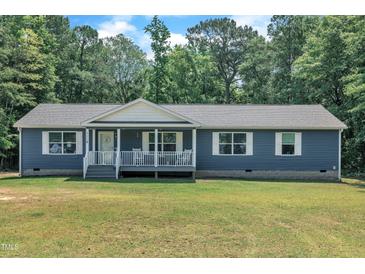 Charming single-story home with blue siding, a welcoming front porch, and a well-maintained lawn at 1118 Oakridge Duncan Rd, Fuquay Varina, NC 27526