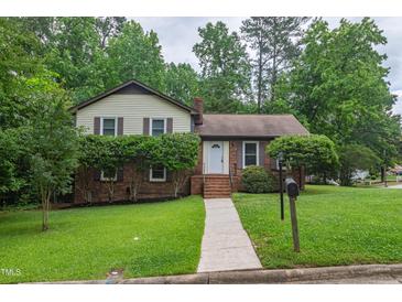 Charming two-story home with landscaped yard, sidewalk, and inviting entrance at 1500 Prisma Ct, Raleigh, NC 27612