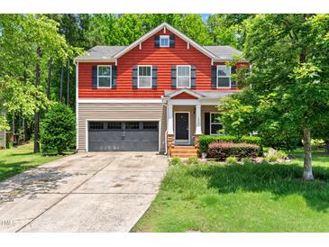 Charming two-story home with a red and beige facade, a two-car garage, and a well-manicured front yard at 1826 Fillmore Dr, Creedmoor, NC 27522