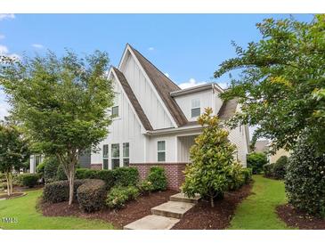 Charming home with white siding, brick accents, manicured landscaping and inviting curb appeal at 208 Jones Hill Rd, Holly Springs, NC 27540