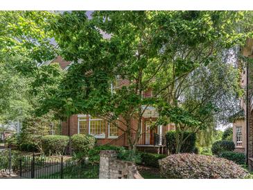 Beautiful brick townhome with lush landscaping and mature trees surrounding the property at 218 W Barbee Chapel Rd, Chapel Hill, NC 27517