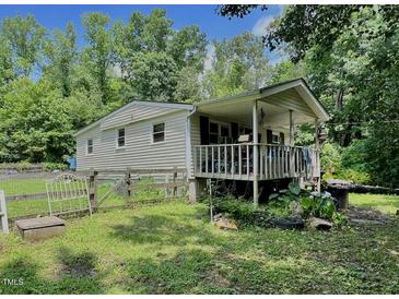 Charming single-story home featuring a covered front porch and a quaint fenced yard at 4601 Orange Grove Rd, Hillsborough, NC 27278