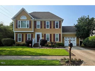 Charming two-story home with red shutters, a well-manicured lawn, and attached two-car garage at 5301 Peacenest Dr, Raleigh, NC 27610