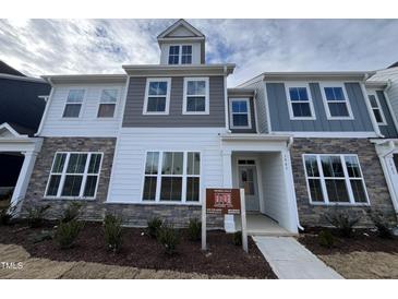 New construction townhome with stone accents, gray and white siding, and available lots sign at 1945 Plott Balsam Dr, Wendell, NC 27591