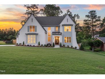Stunning two-story white brick home with a lush lawn and beautiful landscaping at 217 Dublin Rd, Raleigh, NC 27609