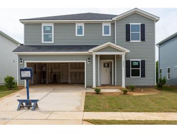 Two-story home featuring an attached garage, gray siding, black shutters, and a well-maintained front lawn at 2258 Cherry Creek Rd, Haw River, NC 27258