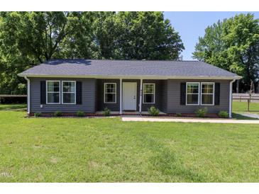 Charming single-story home featuring a well-manicured lawn and gray siding at 420 E Grandview Ave, Liberty, NC 27298