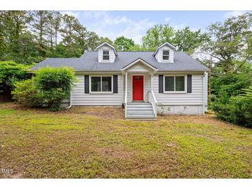 Charming home featuring a bright red front door and inviting curb appeal at 5601 Buffaloe Rd, Raleigh, NC 27616