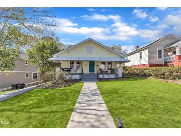 Charming bungalow with a well-manicured lawn, inviting front porch and a blue front door at 602 Dunbar St, Durham, NC 27701