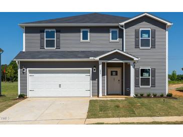Charming two-story home featuring gray siding, a white garage door, and a well-maintained lawn at 693 White Birch Ln, Angier, NC 27501