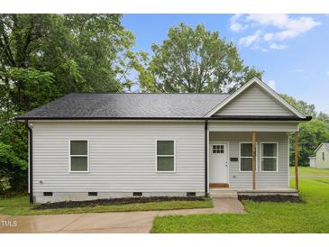 Charming single-story home with light gray siding, black roof, and a welcoming front porch with natural wood columns at 807 S Mebane St., Burlington, NC 27215