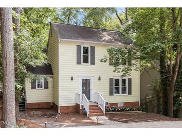 Charming yellow two-story home featuring a welcoming front porch, well-maintained lawn, and dark shutters at 1 Old Towne Pl, Durham, NC 27713