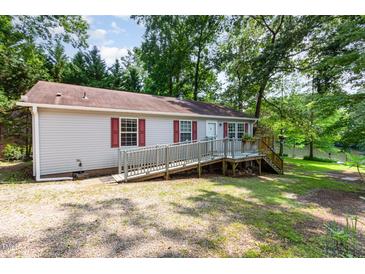 Quaint single-story home with a ramp, surrounded by lush greenery, nestled near a serene lake at 1033 Sagamore Dr, Louisburg, NC 27549