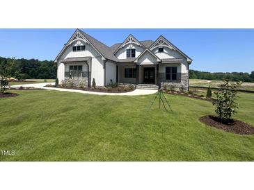 Beautiful new construction featuring stone accents, board and batten, and a professionally landscaped yard at 120 Firefly Ln, Louisburg, NC 27549