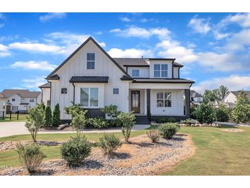 Beautiful two-story modern farmhouse with a landscaped yard and a stone-lined garden at 121 Nate Ct, Wake Forest, NC 27587