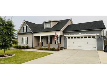 Charming two-story home with gray siding, a covered front porch, and an attached two-car garage at 137 Clydes Point Way, Wendell, NC 27591