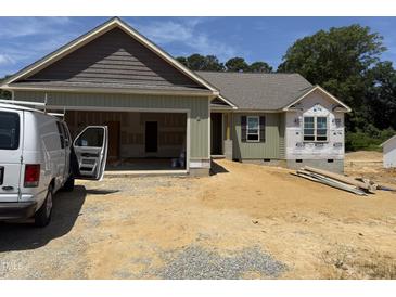View of a home under construction, featuring a two-car garage and green siding at 145 Tee Dr, Selma, NC 27576
