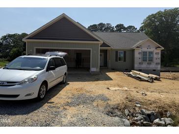 New home featuring a charming exterior with an attached garage and a clean landscape at 145 Tee Dr, Selma, NC 27576