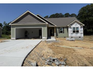Charming single-story home featuring an attached two-car garage and lovely architectural details at 145 Tee Dr, Selma, NC 27576
