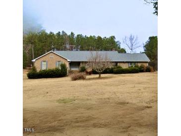 Charming one-story home featuring a classic brick exterior and beautifully landscaped front yard at 1815 Peter Gill Rd, Henderson, NC 27537