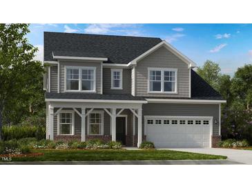 Charming two-story home with gray siding, white trim, covered porch and attached two car garage at 2009 Clydner Dr, Cary, NC 27523