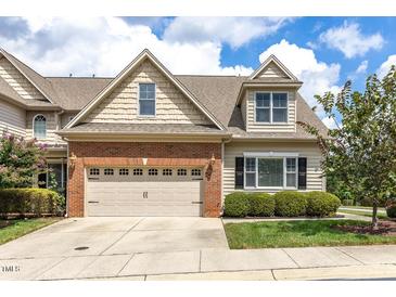 Charming two-story home with a brick and beige exterior and well-maintained landscaping at 215 Dungarven Loop, Cary, NC 27513