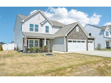 Two story home featuring stone accents, white siding, and a two car garage at 254 Arlie Ln, Lillington, NC 27546