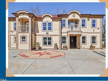 Elegant multi-level home featuring balconies, tan stucco, and an attractive circular driveway design at 318 W Lillington St, Angier, NC 27501