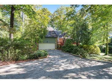 Beautiful home with attached garage nestled among trees, offering privacy and curb appeal at 403 Rutherglen Dr, Cary, NC 27511