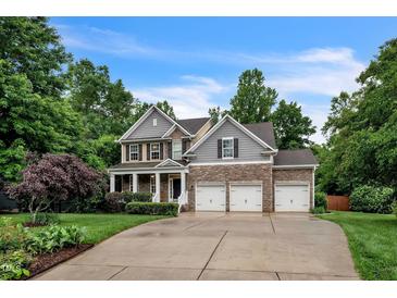 Charming two-story home with stone accents, three-car garage, and well-manicured landscaping at 508 E Hatterleigh Ave, Hillsborough, NC 27278