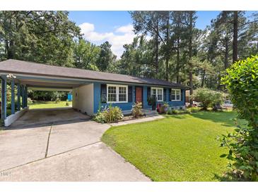 Charming single-story home with blue siding, a well-maintained lawn and an attached carport at 509 Forest Ridge Rd, Garner, NC 27529