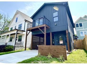 Charming two-story home with a modern design, balcony, and lush green lawn at 517 Coleman St, Raleigh, NC 27610