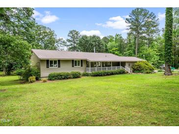 Charming single-story home with a metal roof, white porch railing, and a lush green lawn at 608 20Th St, Butner, NC 27509