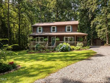 Charming two-story home with a welcoming front porch and a lush, landscaped yard surrounded by mature trees at 6760 Keansburg Rd, Gibsonville, NC 27249