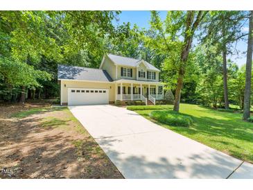 Charming two-story home with a well-manicured lawn, inviting front porch, and a long driveway at 7021 Oviedo Dr, Raleigh, NC 27603