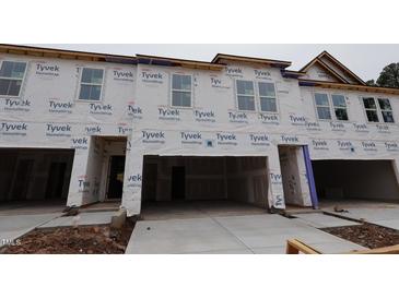 View of new construction townhomes featuring a garage and large windows at 7102 Hubner Pl # 46, Cary, NC 27519