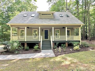 Charming cottage style home with a welcoming front porch and landscaped yard at 8116 Reynard Rd, Chapel Hill, NC 27516
