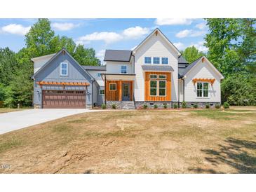 Stunning two-story home featuring mixed siding, a two-car garage and pristine landscaping at 120 Pilot Ridge Rd, Zebulon, NC 27597